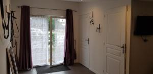 een kamer met een deur en een raam met gordijnen bij Le moulin in Pornic