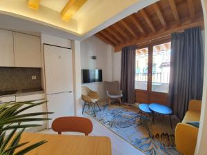a living room with a table and chairs and a kitchen at Silken Casa Platerias Siglo XV in Zaragoza