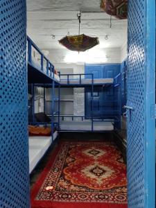 a room with two bunk beds and a rug at Bob hostel in Jodhpur