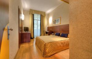 a hotel room with a bed and a window at Central Park Hotel Modena in Modena