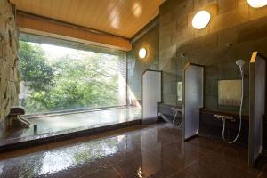 a bathroom with a large window and a shower at Centurion Hakone Bettei in Hakone