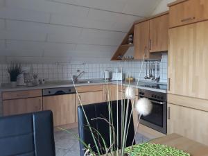 a kitchen with wooden cabinets and a stove top oven at Ferienwohnung Frischkorn in Steinau an der Straße