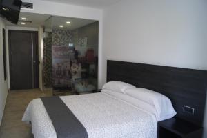 1 dormitorio con cama y espejo grande en Hostal Sanmar, en Figueres