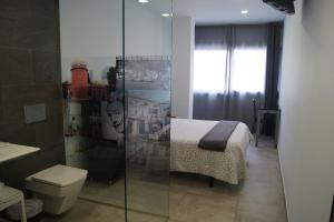 a bathroom with a bed and a shower with a toilet at Hostal Sanmar in Figueres