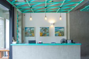una habitación con un mostrador azul con pinturas en la pared en Somerset Mirissa Beach en Mirissa
