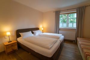 a bedroom with a large bed with a window at Haus Stoertebeker Appartements - Hotel Garni, Seebad Lubmin in Lubmin