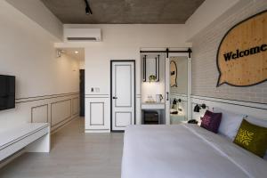 a bedroom with a large white bed and a door at Tian Zhong Hotel in Tianzhong