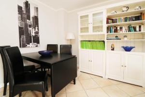 a dining room with a black table and chairs at Fewo Ostsee Urlaub_DOHR in Ostseebad Karlshagen