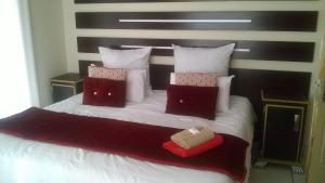a bedroom with a bed with red and white pillows at Baobab Tree Guest House in Huntley