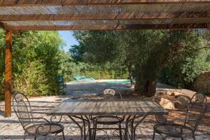 a wooden table and chairs under a wooden pergola at Masseria Pugliese Farm in Ostuni
