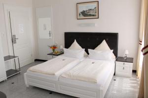 ein Schlafzimmer mit einem großen weißen Bett mit weißen Kissen in der Unterkunft Hotel Am Schloss Biebrich in Wiesbaden
