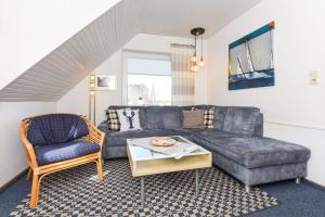 a living room with a couch and a chair at Haus Stoertebeker in Neuharlingersiel