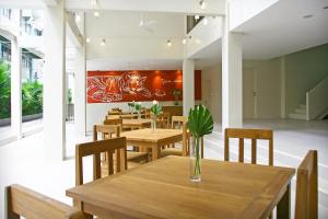 una sala da pranzo con tavoli e sedie in legno di CHERN Bangkok a Bangkok