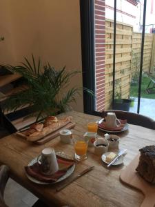 - une table en bois avec des aliments pour le petit-déjeuner dans l'établissement La bulle de Gaston, à Toulouse