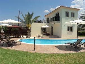 a villa with a swimming pool and a house at Citrus Grove Villa in Argaka