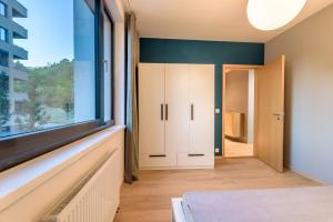 um quarto com uma grande janela e um armário em Bratislava center, river front, private parking included em Bratislava