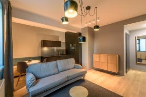 a living room with a couch and a kitchen at Bratislava center, river front, private parking included in Bratislava