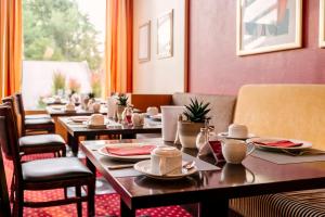 une rangée de tables et de chaises dans un restaurant dans l'établissement Hotel am Jungfernstieg, à Stralsund