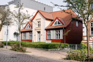 ein Haus mit rotem Dach und einem Fahrrad davor in der Unterkunft Hotel am Jungfernstieg in Stralsund