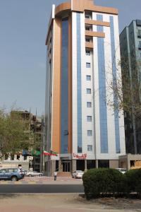 um edifício alto com um carro estacionado em frente em Laguna Hotel Suites em Kuwait