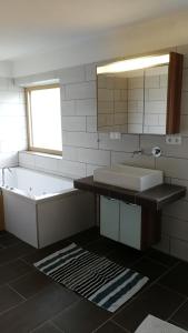 a bathroom with a tub and a sink and a mirror at Ferienwohnung Philipp in Leutasch