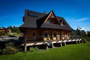 a large wooden house on a wooden deck at Villa z widokiem na Giewont in Kościelisko
