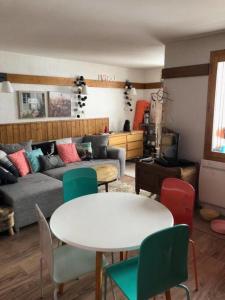 uma sala de estar com um sofá, uma mesa e cadeiras em Modern Apartment In La Plagne 1800 em Mâcot La Plagne