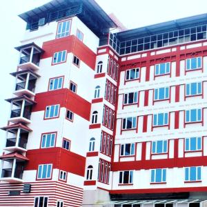 a tall red and white building with many windows at The Hotel Canoe in Kannur
