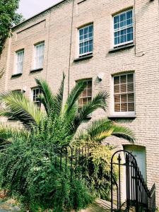 ein Backsteingebäude mit einer Palme davor in der Unterkunft Luxury Central London 3 Bedroom Family House in London