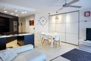 Arana Apartment by BasqueHomes في سان سيباستيان: مطبخ وغرفة معيشة مع طاولة وكراسي