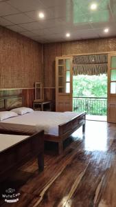 1 dormitorio con 1 cama grande y balcón en MEKONG NATURE LODGE, en Vĩnh Long