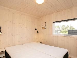 a bed in a room with a window at 14 person holiday home in Idestrup in Marielyst