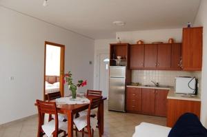 una cucina con tavolo e una cucina con frigorifero di Villa Vourda a Marathokampos