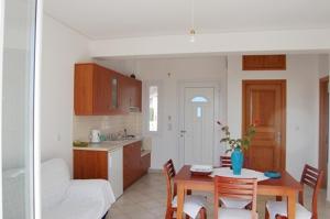 Una cocina y un comedor con mesa y sillas. en Villa Vourda, en Marathokampos