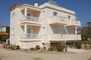 ein großes weißes Gebäude mit Balkon darüber in der Unterkunft Villa Vourda in Marathokampos