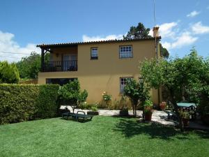 Una gran casa amarilla con un patio con césped sidx sidx sidx sidx en Casa Rosinha Menor, en Riba de Âncora