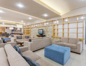 a living room with couches and a blue stool at Alykanas Village Resort in Alikanas