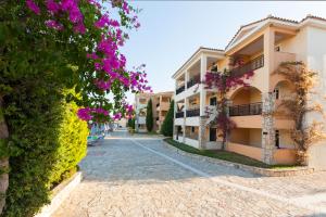 a street in a resort with purple flowers at Alykanas Village Resort in Alikanas