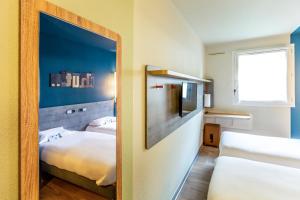 a small room with two beds and a mirror at ibis budget Besan&ccedil;on Centre Gare in Besan&ccedil;on
