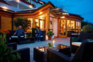 two people sitting on the patio of a house at Vitalhotel Krainz in Loipersdorf bei Fürstenfeld