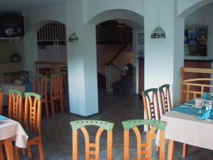 ein Esszimmer mit Tischen und Stühlen und eine Treppe in der Unterkunft Hotell De Tolly in Tõrva