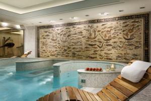 a large swimming pool in a hotel room with a mural at Principi di Piemonte | UNA Esperienze in Turin