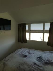 Un dormitorio con una cama grande y una ventana en Huisje aan zee en Middelkerke