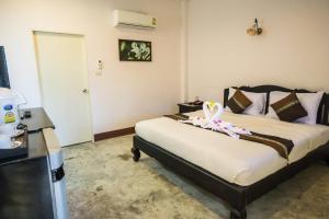 um quarto com uma cama com uma flor em Chang Cliff Resort em Ko Chang