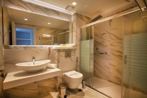 La salle de bains est pourvue d'un lavabo, de toilettes et d'une douche. dans l'établissement Rethymno Palace, à Adelianos Kampos