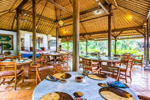 um restaurante com mesas e cadeiras num quarto em Taman Selini Wahana Beach Resort em Pemuteran