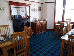 a dining room with a table and chairs and a fireplace at Solheim Guest House in Lerwick