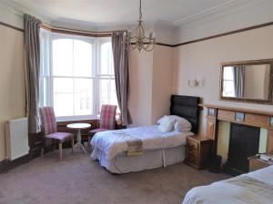 Habitación de hotel con cama y chimenea en Solheim Guest House, en Lerwick