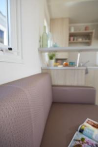 a room with a kitchen with a couch and a shelf at Càmping Bellsol in Pineda de Mar
