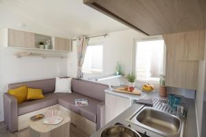 a small living room with a couch and a kitchen at Càmping Bellsol in Pineda de Mar